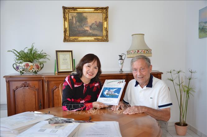 Ông Jean Marie Jacquemin chia sẻ với bà Trần Thị Kim Hoa về cuốn sách "1968-1973 Verrières-le-Buisson: Bến bờ bình yên". Ảnh: Ngọc Hiệp/TTXVN